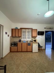 a kitchen with wooden cabinets and a white refrigerator at Dream Catcher 5 in Agia Theodoti