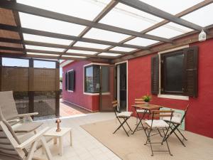 a patio with chairs and a table and a red wall at Casa Zapato in La Pared