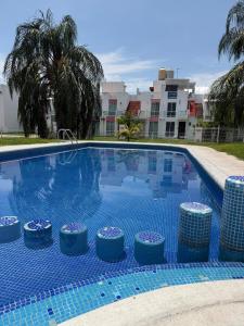 a large swimming pool with blue tiles on it at Casa privada, alberca, jacuzzi y asador Teques in Jojutla