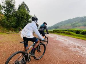 two people riding bikes down a dirt road at Blue Home Stay in Janjagiro