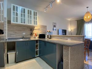 a kitchen with blue cabinets and a counter top at Mountain View luxe chalet Ras elhikma families only in Ras Elhekma