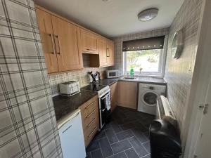 a small kitchen with a sink and a stove at Sleeps4-FamilyFriendly-FreeParking- Nc500 in Wick