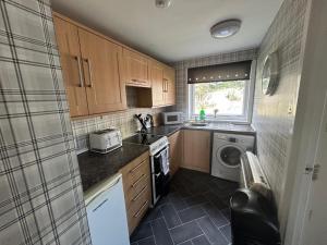 a small kitchen with a sink and a dishwasher at Sleeps4-FamilyFriendly-FreeParking- Nc500 in Wick