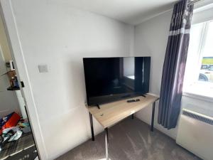 a flat screen tv sitting on a table in a room at Sleeps4-FamilyFriendly-FreeParking- Nc500 in Wick +13 photos