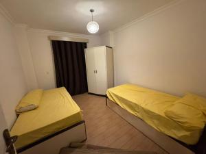 a small bedroom with two beds and a refrigerator at الرحاب سيتي in New cairo