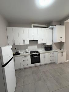 a kitchen with white cabinets and a refrigerator at Яровиця 167 in Lutsk