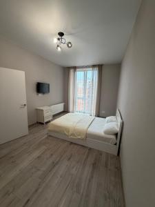 a bedroom with a bed and a large window at Яровиця 167 in Lutsk
