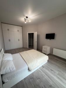 a bedroom with a white bed and a flat screen tv at Яровиця 167 in Lutsk
