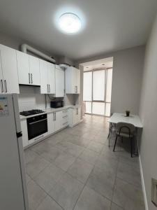 a kitchen with white cabinets and a table in it at Яровиця 167 in Lutsk