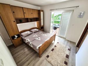 a bedroom with a bed and a large window at Apartments Benkovic in Baška
