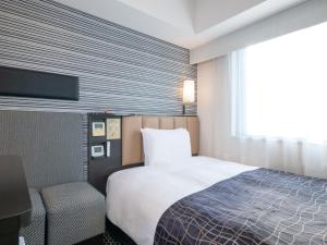 a hotel room with a bed and a tv at APA Hotel Keisei Ueno Ekimae in Tokyo
