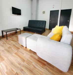 a living room with a white couch and a table at Hostel HM Caribe in Santa Marta