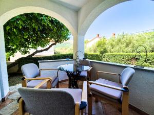 a patio with chairs and a table and a small table at Apartments Benkovic in Baška