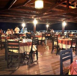 a restaurant with tables and chairs with people sitting at them at Gran Lençóis Flat Residence Barreirinhas in Barreirinhas