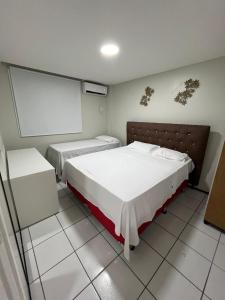 a bedroom with two beds and a projection screen at Gran Lençóis Flat Residence Barreirinhas in Barreirinhas +8 photos