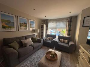 a living room with two couches and a table at Old Schoolhouse Coleraine in Coleraine