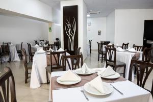 ein Esszimmer mit Tischen und Stühlen mit weißen Tischdecken in der Unterkunft Win & Win Hotel & Casino Piura in Piura
