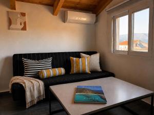 a living room with a black couch and a table at Ocean Breeze Luxury Loft in Psathopyrgos