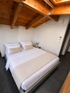 a large white bed in a room with wooden ceilings at Ocean Breeze Luxury Loft in Psathopyrgos