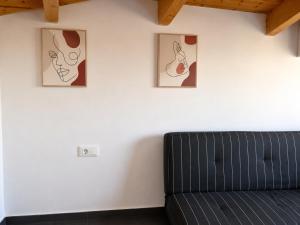 a black couch in a room with three pictures on the wall at Ocean Breeze Luxury Loft in Psathopyrgos