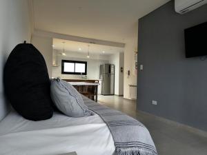 ein Schlafzimmer mit einem Bett, auf dem ein schwarzes Kissen liegt in der Unterkunft LEVEL Terrazas premium con parrillas privadas in Bahía Blanca
