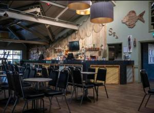 a bar with tables and chairs in a restaurant at Netty's Retreat in Hemsby