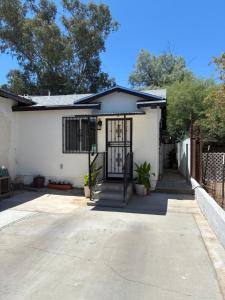 a white house with a gate and a driveway at Quail's Nest - Downtown Studio in Tucson