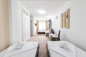 a room with two beds and a living room at Aparthotel HayatHills in Sarajevo