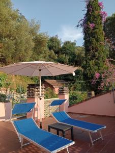 two blue chairs and an umbrella on a patio at Roses House in Sestri Levante