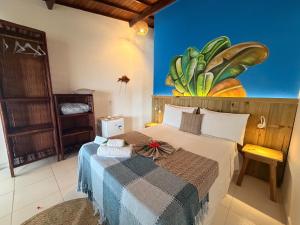 a bedroom with a bed and a painting on the wall at Pousada Nascente do Sol in Ilha de Boipeba