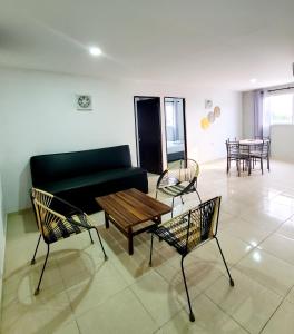 a living room with a couch and chairs and a table at Hostel HM Caribe in Santa Marta