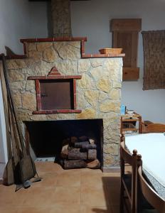 a stone fireplace in a living room with a table at La casetta dei carciofi in San Fratello
