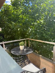 a table and chairs on a balcony with a tree at Cozy Central View -Self Check-In 24h in Reşiţa