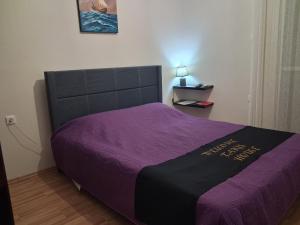 a bed in a bedroom with a purple blanket at TAKIS HOUSE in Káto Panayía