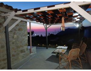 a patio with a table and chairs and a sunset at La casetta dei carciofi in San Fratello