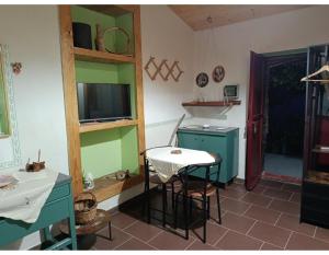 a kitchen with a table and a television in a room at La casetta dei carciofi in San Fratello