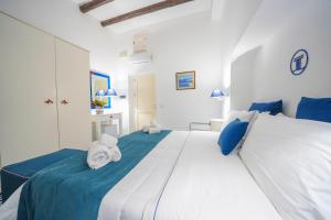 a bedroom with a large white bed with blue pillows at Hotel La Terrazza in Panarea
