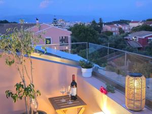 a table with a bottle of wine and glasses on a balcony at Piano House in Corfu