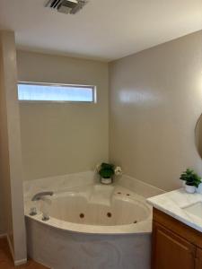 a white bath tub in a bathroom with a window at Quail's Nest - Downtown Studio in Tucson +29 photos