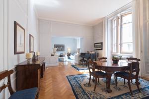una sala da pranzo con tavolo e sedie e un soggiorno di Luxury Apartment Central Florence a Firenze