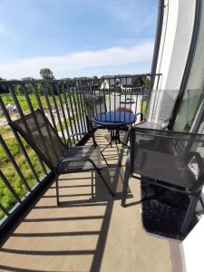 a balcony with two chairs and a table on it at ApartamentyDiana in Pogórze