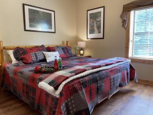 a bedroom with a bed with a plaid blanket at Rustic Cabin, Fire Pit with HotTub, Mountain Views, Peaceful Location in Sevierville +18 photos