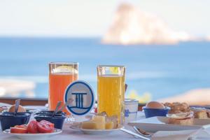a table with plates of food and two glasses of orange juice at Hotel La Terrazza in Panarea