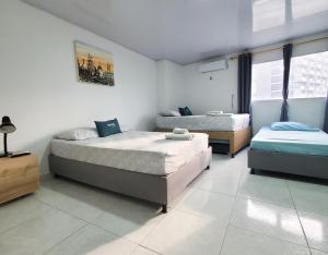 two beds in a room with two beds sidx sidx sidx at Hostel HM Caribe in Santa Marta +58 photos