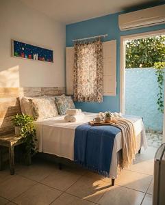 a bedroom with a bed with a blue wall at Pousada Universo Arraial in Arraial d'Ajuda +66 photos