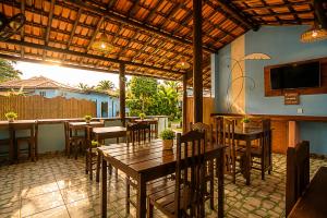 a restaurant with tables and chairs and a flat screen tv at Pousada Universo Arraial in Arraial d'Ajuda