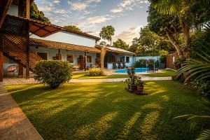 a yard with a house and a pool at Pousada Universo Arraial in Arraial d'Ajuda