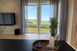 a candle sitting on a table in front of a window at Oceanfront Infinity Lodge, Lofoten in Vestvågøya