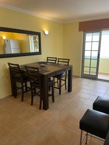 a dining room with a table and chairs and a mirror at Refúgio Das Ondas in Praia da Vitória