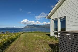 a house with a view of the water and mountains at Oceanfront Infinity Lodge, Lofoten in Vestvågøya